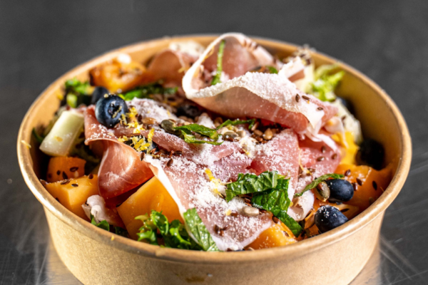 En sallad med prosciutto, ruccola, picklad melon och andra grönsaker.