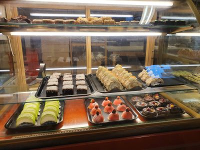 Ett displayfodral fyllt med olika bakverk i ett bageri.